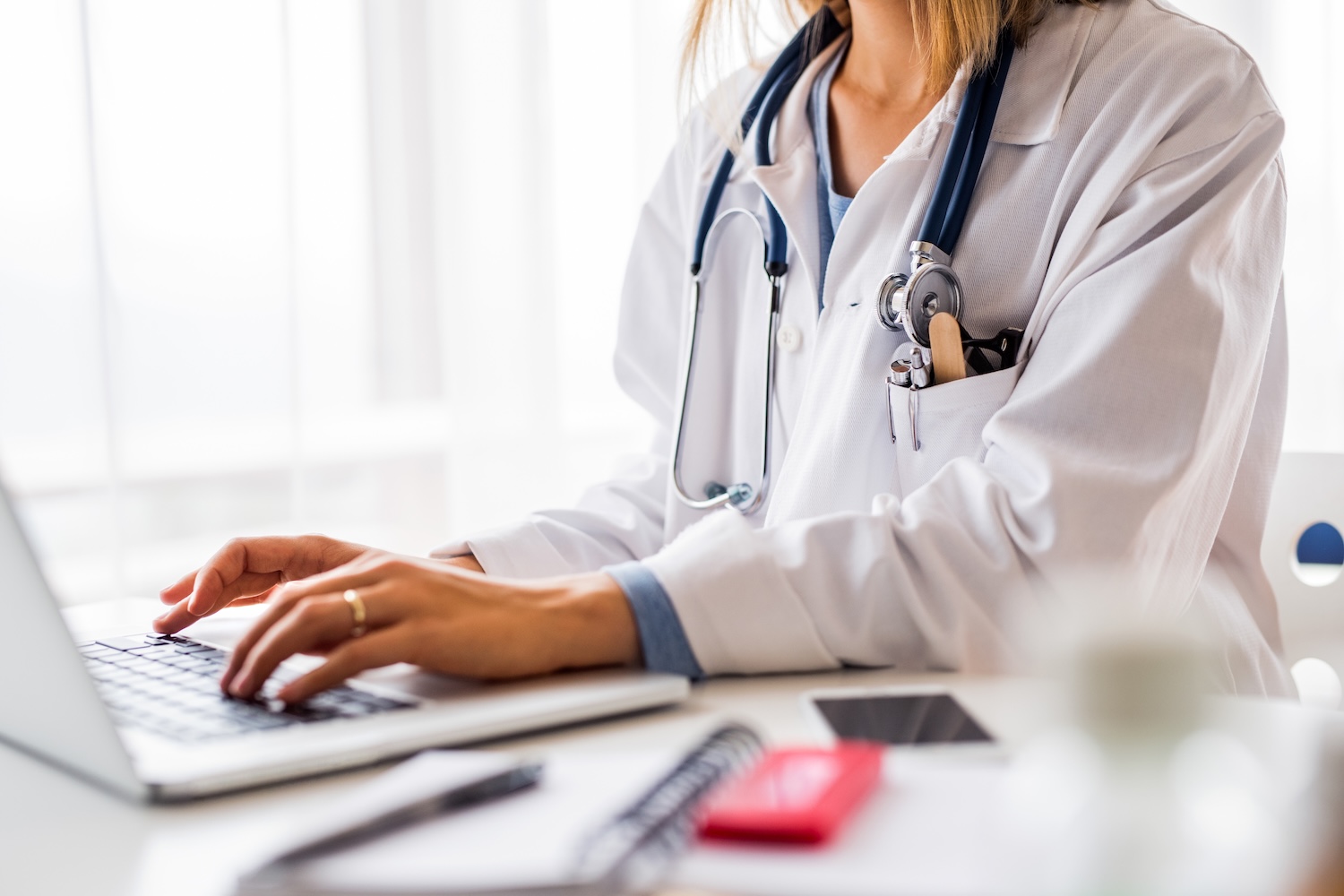 Female fertility doctor with laptop working at the office desk.